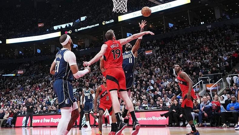 Feb 28, 2024; Toronto, Ontario, CAN; Dallas Mavericks guard Kyrie Irving (11) drives to the basket as Toronto Raptors center Jakob Poeltl (19) tries to defend during the second quarter at Scotiabank Arena. Mandatory Credit: Nick Turchiaro-USA TODAY Sports
