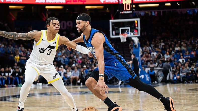 Feb 29, 2024; Orlando, Florida, USA; Orlando Magic guard Jalen Suggs (4) dribbles the ball against Utah Jazz guard Keyonte George (3) in the first quarter at Kia Center. Mandatory Credit: Jeremy Reper-USA TODAY Sports