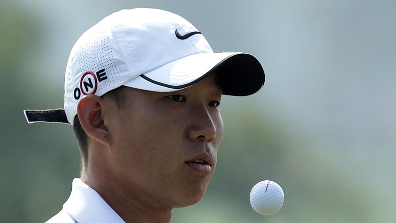 Anthony Kim of the U.S. reaches for the ball as he plays on the 1th hole during the 2009 HSBC Champions golf tournament in Shanghai November 5, 2009.