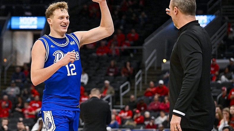 Mar 5, 2023; St. Louis, MO, USA; Drake Bulldogs guard Tucker DeVries (12) celebrates with head coach Darian DeVries during the second half against the Bradley Braves in the finals of the Missouri Valley Conference Tournament at Enterprise Center. Mandatory Credit: Jeff Curry-USA TODAY Sports
