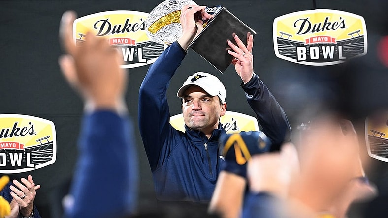 Dec 27, 2023; Charlotte, NC, USA; West Virginia Mountaineers head coach Neal Brown holds up the championship trophy after the game at Bank of America Stadium. Mandatory Credit: Bob Donnan-USA TODAY Sports