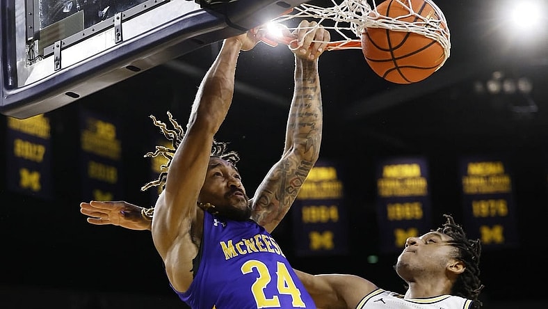 Dec 29, 2023; Ann Arbor, Michigan, USA;  McNeese State Cowboys forward Christian Shumate (24) dunks on Michigan Wolverines forward Tarris Reed Jr. (32) in the second half at Crisler Center. Mandatory Credit: Rick Osentoski-USA TODAY Sports