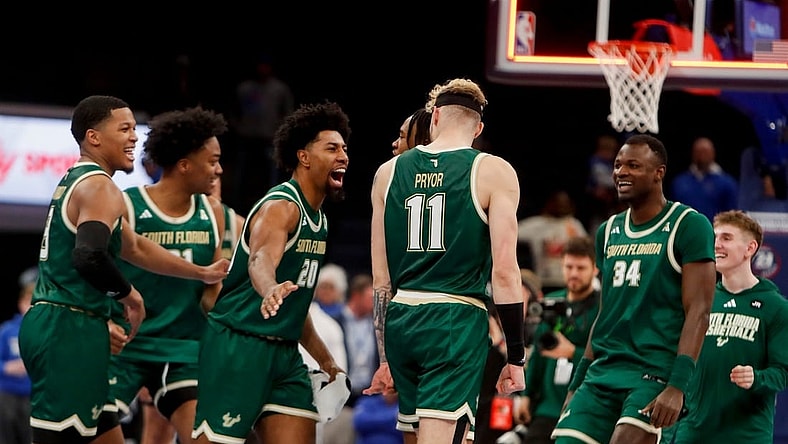 South Florida's Sam Hines Jr. (20) slaps Kasean Pryor (11) on the back as the team celebrates as the buzzer sounds after defeating Memphis 74-73 at FedExForum in Memphis, Tenn., on Thursday, January 18, 2024.