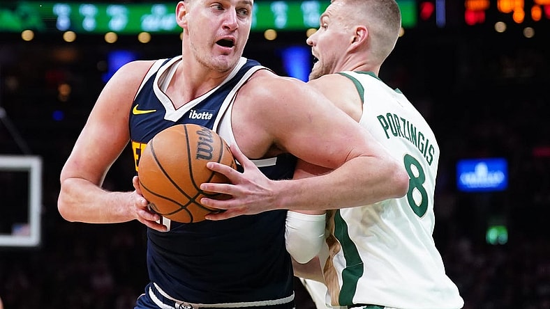 Jan 19, 2024; Boston, Massachusetts, USA; Denver Nuggets center Nikola Jokic (15) works the ball around Boston Celtics center Kristaps Porzingis (8) in the second quarter at TD Garden. Mandatory Credit: David Butler II-USA TODAY Sports