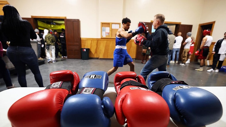 Michael Cappiello owner of Cappiello Boxing Gym with his boxer Will Longwe, 27, who hits the hand pads against Mchilandy Noel of Bishop's Gym in West Bridgewater during the Southern New England Golden Gloves opening night at the Fall River PAL Hall on Saturday, Jan. 20, 2024.