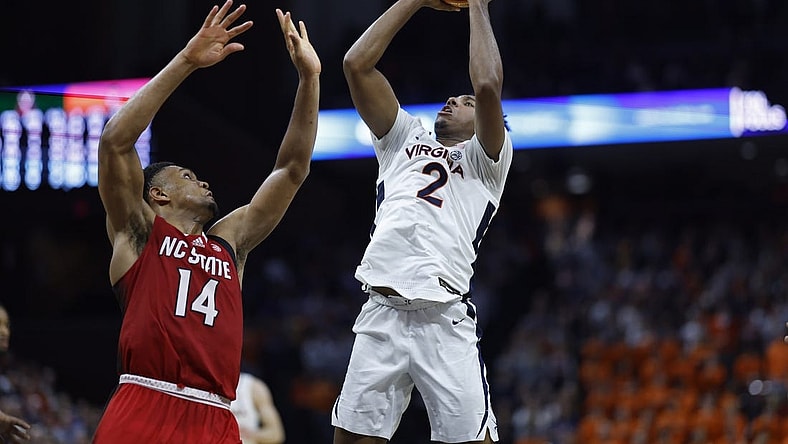 Jan 24, 2024; Charlottesville, Virginia, USA; Virginia Cavaliers guard Reece Beekman (2) shoots the ball as North Carolina State Wolfpack guard Casey Morsell (14) defends in overtime at John Paul Jones Arena. Mandatory Credit: Geoff Burke-USA TODAY Sports