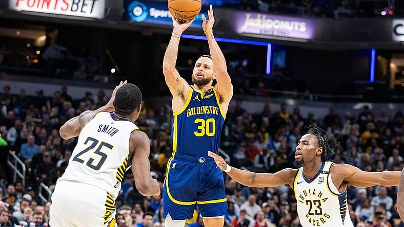 Feb 8, 2024; Indianapolis, Indiana, USA; Golden State Warriors guard Stephen Curry (30) shoots the ball while Indiana Pacers forward Jalen Smith (25) and forward Aaron Nesmith (23)  defend in the first half at Gainbridge Fieldhouse. Mandatory Credit: Trevor Ruszkowski-USA TODAY Sports