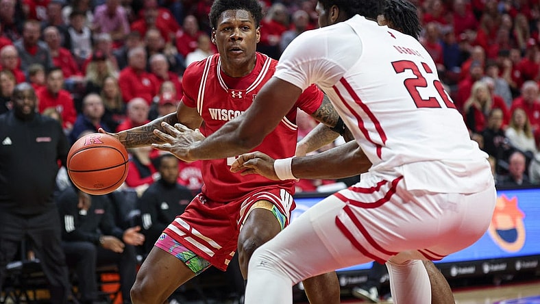 Feb 10, 2024; Piscataway, New Jersey, USA; Wisconsin Badgers guard AJ Storr (left) dribbles the ball against Rutgers Scarlet Knights center Emmanuel Ogbole (22) during the first half at Jersey Mike's Arena. Mandatory Credit: Vincent Carchietta-USA TODAY Sports