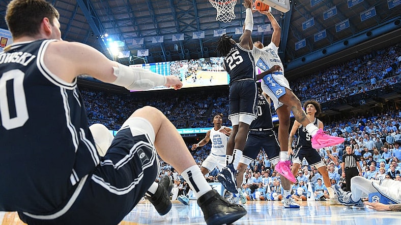 Feb 3, 2024; Chapel Hill, North Carolina, USA; North Carolina Tar Heels forward Armando Bacot (5) shoots as Duke Blue Devils forward Mark Mitchell (25) defends and center Kyle Filipowski (30) sits on the floor in the second half at Dean E. Smith Center. Mandatory Credit: Bob Donnan-USA TODAY Sports