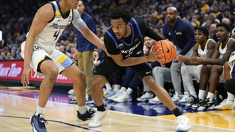 Feb 21, 2024; Milwaukee, Wisconsin, USA;  DePaul Blue Demons guard Chico Carter Jr. (2) holds the ball away from Marquette Golden Eagles guard Stevie Mitchell (4) during the first half at Fiserv Forum. Mandatory Credit: Jeff Hanisch-USA TODAY Sports