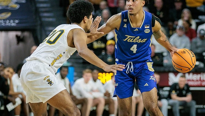 Feb 21, 2024; Wichita, Kansas, USA; Tulsa Golden Hurricane guard PJ Haggerty (4) brings the ball up court around Wichita State Shockers guard Harlond Beverly (20) during the second half at Charles Koch Arena. Mandatory Credit: William Purnell-USA TODAY Sports