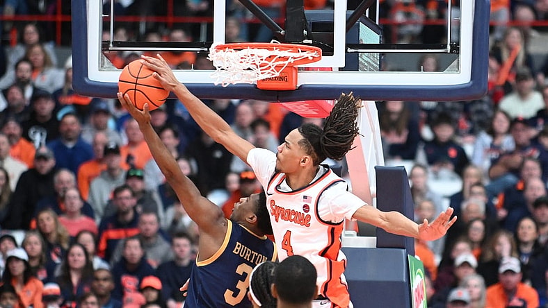 Feb 24, 2024; Syracuse, New York, USA; Syracuse Orange forward Chris Bell (4) blocks a shot by Notre Dame Fighting Irish guard Markus Burton (3) in the second half at the JMA Wireless Dome. Mandatory Credit: Mark Konezny-USA TODAY Sports
