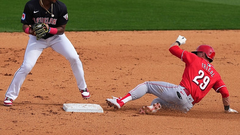 Cincinnati Reds center fielder TJ Friedl (29) slides into the second base on a double play turned by the Cleveland Guardians defense in the fifth inning during a MLB spring training baseball game, Saturday, Feb. 24, 2024, at Goodyear Ballpark in Goodyear, Ariz.