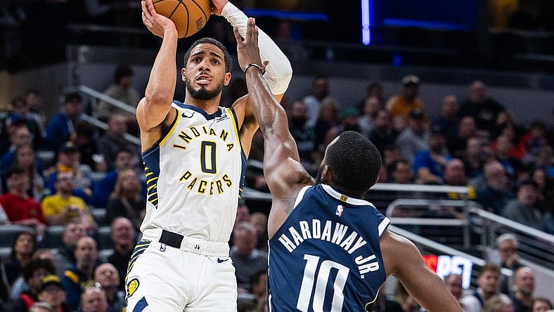 Feb 25, 2024; Indianapolis, Indiana, USA; Indiana Pacers guard Tyrese Haliburton (0) shoots the ball while Dallas Mavericks forward Tim Hardaway Jr. (10) defends in the first half at Gainbridge Fieldhouse. Mandatory Credit: Trevor Ruszkowski-USA TODAY Sports