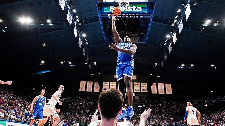 Feb 27, 2024; Lawrence, Kansas, USA; Brigham Young Cougars forward Fousseyni Traore (45) shoots as Kansas Jayhawks forward Parker Braun (23) falls below him during the second half at Allen Fieldhouse. Mandatory Credit: Denny Medley-USA TODAY Sports