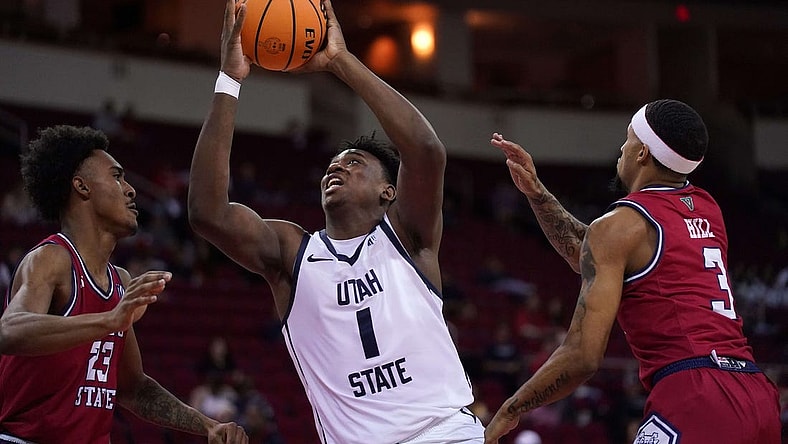 Feb 27, 2024; Fresno, California, USA; Utah State Aggies forward Great Osobor (1) drives to the hoop between Fresno State Bulldogs guard Leo Colimerio (23) and guard Isaiah Hill (3) in the first half at the Save Mart Center. Mandatory Credit: Cary Edmondson-USA TODAY Sports
