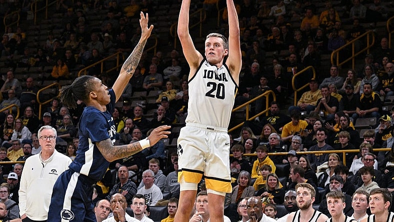 Feb 27, 2024; Iowa City, Iowa, USA; Iowa Hawkeyes forward Payton Sandfort (20) shoots a three point basket over Penn State Nittany Lions guard Nick Kern Jr. (3) as head coach Fran McCaffery looks on during the second half at Carver-Hawkeye Arena. Mandatory Credit: Jeffrey Becker-USA TODAY Sports