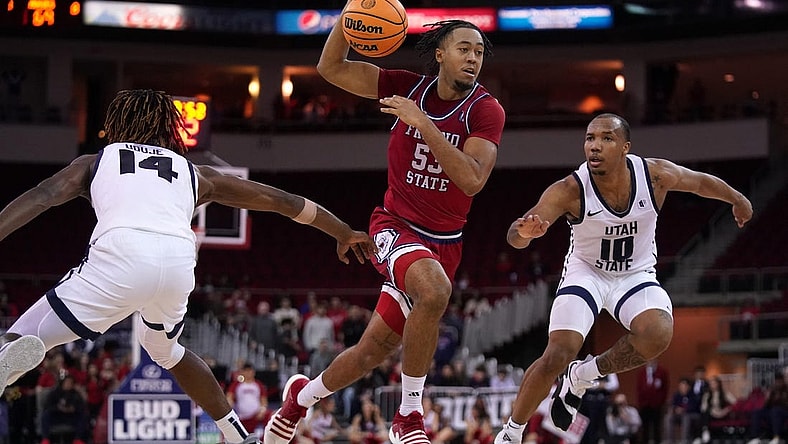 Feb 27, 2024; Fresno, California, USA; Fresno State Bulldogs guard Xavier DuSell (53) drives past Utah State Aggies guard Josh Uduje (14) and guard Darius Brown II (10) in overtime at the Save Mart Center. Mandatory Credit: Cary Edmondson-USA TODAY Sports