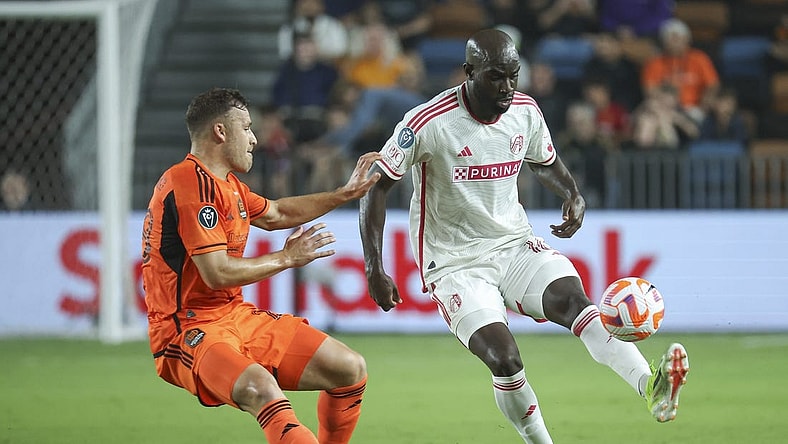 Feb 27, 2024; Houston, TX, USA; St. Louis CITY SC forward Samuel Adeniran (16) attempts to control the ball as Houston Dynamo FC defender Erik Sviatchenko (28) defends during the second half at Shell Energy Stadium. Mandatory Credit: Troy Taormina-USA TODAY Sports