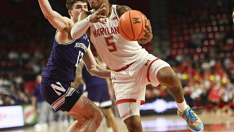 Feb 28, 2024; College Park, Maryland, USA; Maryland Terrapins guard DeShawn Harris-Smith (5) shoots on Northwestern Wildcats guard Brooks Barnhizer (13) during the second half at Xfinity Center. Mandatory Credit: Tommy Gilligan-USA TODAY Sports