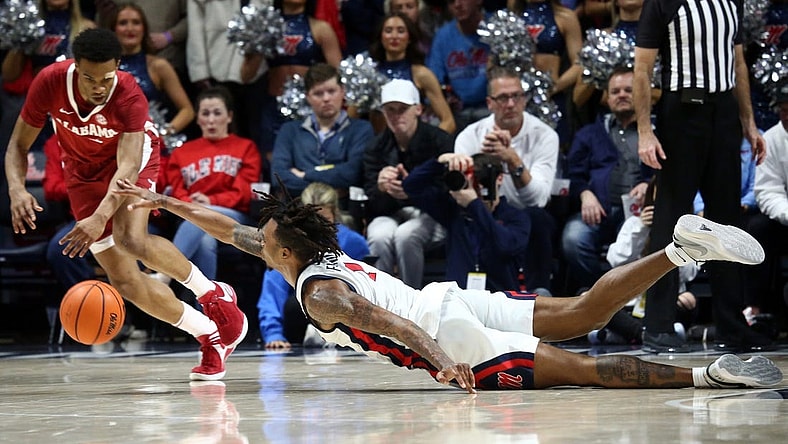 Feb 28, 2024; Oxford, Mississippi, USA; Mississippi Rebels guard Allen Flanigan (7) dives for a loose ball as Alabama Crimson Tide guard Rylan Griffen (3) scoops it up during the first half at The Sandy and John Black Pavilion at Ole Miss. Mandatory Credit: Petre Thomas-USA TODAY Sports