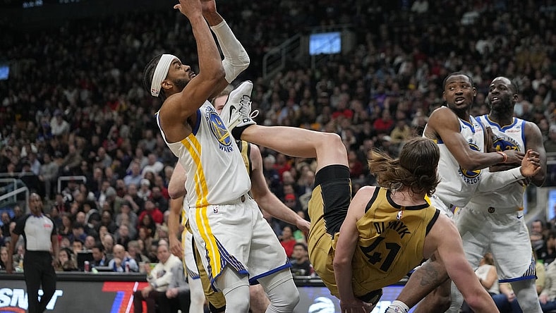 Mar 1, 2024; Toronto, Ontario, CAN; Golden State Warriors guard Moses Moody (4) comes down with a rebound as Toronto Raptors forward Kelly Olynyk (41) falls to the court during the first half at Scotiabank Arena. Mandatory Credit: John E. Sokolowski-USA TODAY Sports