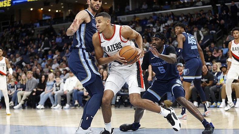 Mar 1, 2024; Memphis, Tennessee, USA; Portland Trail Blazers forward Kris Murray (8) drives to the basket as Memphis Grizzlies forward-center Santi Aldama (7) and Memphis Grizzlies guard Vince Williams Jr. (5) defend during the first half at FedExForum. Mandatory Credit: Petre Thomas-USA TODAY Sports