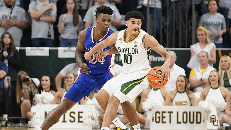 Mar 2, 2024; Waco, Texas, USA; Baylor Bears guard RayJ Dennis (10) is defended by Kansas Jayhawks forward K.J. Adams Jr. (24) during the first half at Paul and Alejandra Foster Pavilion. Mandatory Credit: Raymond Carlin III-USA TODAY Sports