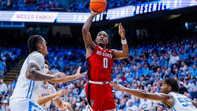 Mar 2, 2024; Chapel Hill, North Carolina, USA; North Carolina State Wolfpack guard DJ Horne (0) shoots between North Carolina Tar Heels forward Armando Bacot (5) (left) and forward Harrison Ingram (55) during the first half at Dean E. Smith Center. Mandatory Credit: Scott Kinser-USA TODAY Sports