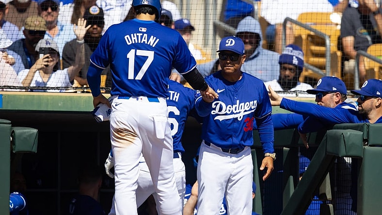 Los Angeles Dodgers designated hitter Shohei Ohtani (17) celebrates with manager Dave Roberts after scoring against the Colorado Rockies during a spring training game at Camelback Ranch-Glendale. Mandatory Credit: Mark J. Rebilas-USA TODAY Sports
