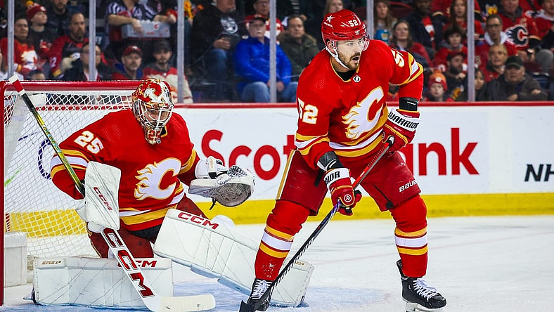Mar 4, 2024; Calgary, Alberta, CAN; Calgary Flames defenseman MacKenzie Weegar (52) controls the puck in front of Calgary Flames goaltender Jacob Markstrom (25) during the first period against the Seattle Kraken at Scotiabank Saddledome. Mandatory Credit: Sergei Belski-USA TODAY Sports