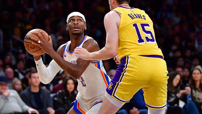 Mar 4, 2024; Los Angeles, California, USA;  Oklahoma City Thunder guard Shai Gilgeous-Alexander (2) controls the ball against Los Angeles Lakers guard Austin Reaves (15) during the second half at Crypto.com Arena. Mandatory Credit: Gary A. Vasquez-USA TODAY Sports