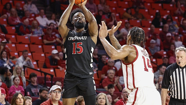 Mar 5, 2024; Norman, Oklahoma, USA; Cincinnati Bearcats forward John Newman III (15) shoots as Oklahoma Sooners forward Jalon Moore (14) defends during the first half at Lloyd Noble Center. Mandatory Credit: Alonzo Adams-USA TODAY Sports