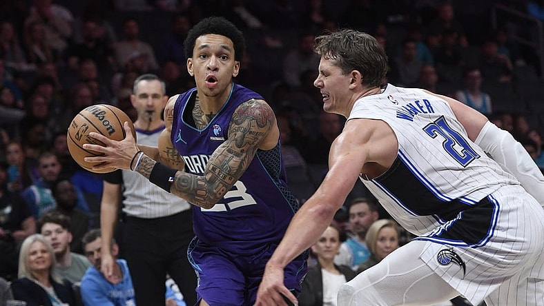 Mar 5, 2024; Charlotte, North Carolina, USA;  Charlotte Hornets guard Tre Mann (23) drives past Orlando Magic center Moritz Wagner (21) during the second half at the Spectrum Center. Mandatory Credit: Sam Sharpe-USA TODAY Sports
