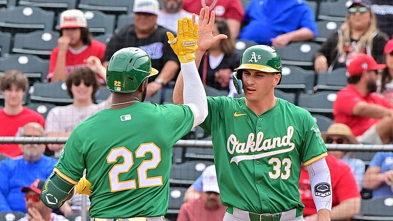 Mar 6, 2024; Tempe, Arizona, USA;  Oakland Athletics right fielder Miguel Andujar (22) celebrates with left fielder JJ Bleday (33) after hitting a three run home run in the first inning against the Los Angeles Angels during a spring training game at Tempe Diablo Stadium. Mandatory Credit: Matt Kartozian-USA TODAY Sports