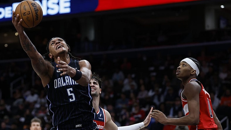 Mar 6, 2024; Washington, District of Columbia, USA; Orlando Magic forward Paolo Banchero (5) shoots the ball as Washington Wizards guard Bilal Coulibaly (0) looks on in the first half at Capital One Arena. Mandatory Credit: Geoff Burke-USA TODAY Sports