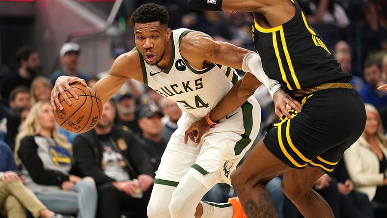 Mar 6, 2024; San Francisco, California, USA; Milwaukee Bucks forward Giannis Antetokounmpo (34) dribbles the ball next to Golden State Warriors forward Jonathan Kuminga (00) in the second quarter at the Chase Center. Mandatory Credit: Cary Edmondson-USA TODAY Sports