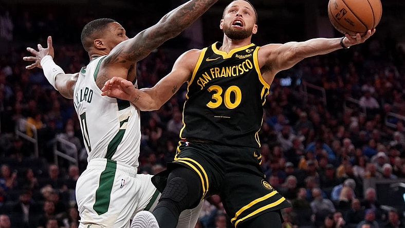 Mar 6, 2024; San Francisco, California, USA; Golden State Warriors guard Stephen Curry (30) shoots the ball while being defended by Milwaukee Bucks guard Damian Lillard (0) in the third quarter at the Chase Center. Mandatory Credit: Cary Edmondson-USA TODAY Sports