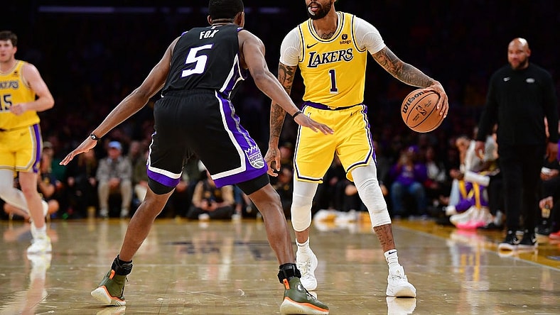 Mar 6, 2024; Los Angeles, California, USA; Los Angeles Lakers guard D'Angelo Russell (1) controls the ball against Sacramento Kings guard De'Aaron Fox (5) during the second half at Crypto.com Arena. Mandatory Credit: Gary A. Vasquez-USA TODAY Sports