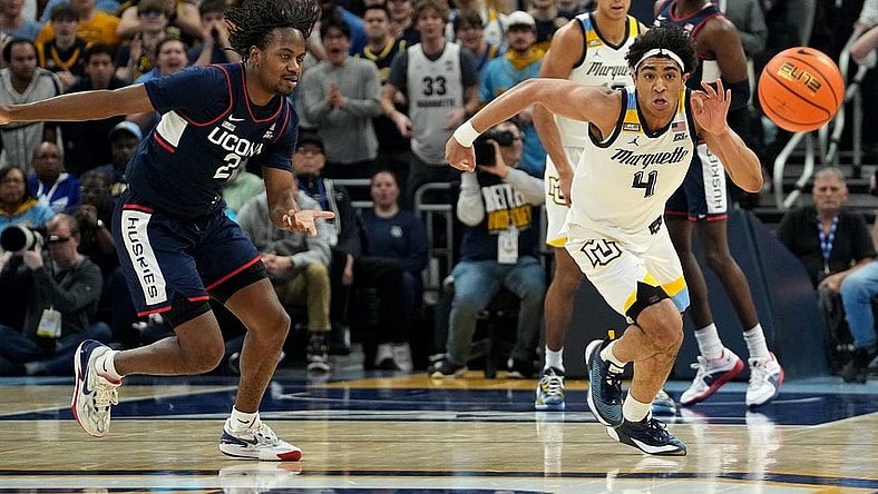 Marquette guard Stevie Mitchell (4) beats UConn guard Tristen Newton (2) to a loose ball during the first half of their game Wednesday, March 6, 2024 at Fiserv Forum in Milwaukee, Wisconsin.