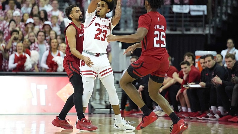 Mar 7, 2024; Madison, Wisconsin, USA;  Wisconsin Badgers guard Chucky Hepburn (23) looks to pass the ball against Rutgers Scarlet Knights guard Noah Fernandes (2) and Rutgers Scarlet Knights guard Jeremiah Williams (25) during the first half at Kohl Center. Mandatory Credit: Kayla Wolf-USA TODAY Sports