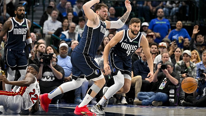 Mar 7, 2024; Dallas, Texas, USA; Dallas Mavericks guard Luka Doncic (77) and forward Maxi Kleber (42) chase the loose ball during the second half against the Miami Heat at the American Airlines Center. Mandatory Credit: Jerome Miron-USA TODAY Sports