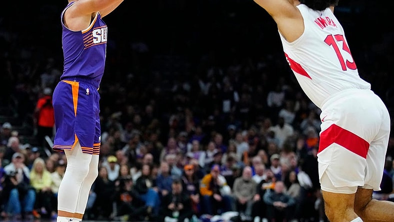 Suns guard Grayson Allen (8) makes a three pointer against Raptors forward Jordan Nwora (13) during a game at the Footprint Center.