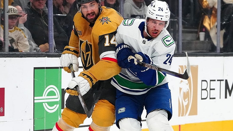 Mar 7, 2024; Las Vegas, Nevada, USA; Vegas Golden Knights defenseman Nicolas Hague (14) checks Vancouver Canucks center Pius Suter (24) during the first period at T-Mobile Arena. Mandatory Credit: Stephen R. Sylvanie-USA TODAY Sports