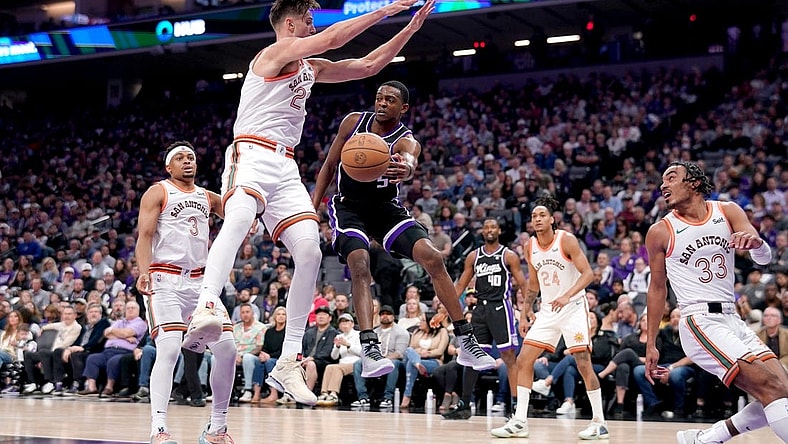Mar 7, 2024; Sacramento, California, USA; Sacramento Kings guard De'Aaron Fox (5) passes the ball around the reach of San Antonio Spurs forward Zach Collins (23) in the second quarter at the Golden 1 Center. Mandatory Credit: Cary Edmondson-USA TODAY Sports