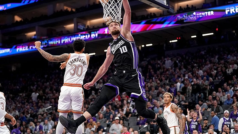 Mar 7, 2024; Sacramento, California, USA; Sacramento Kings forward Domantas Sabonis (10) dunks the ball in front of San Antonio Spurs forward Julian Champagnie (30) in the second quarter at the Golden 1 Center. Mandatory Credit: Cary Edmondson-USA TODAY Sports