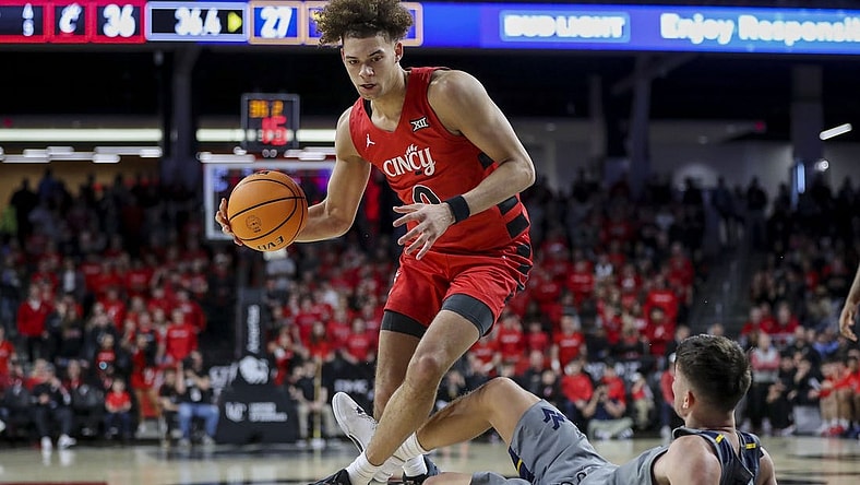 Mar 9, 2024; Cincinnati, Ohio, USA; Cincinnati Bearcats guard Dan Skillings Jr. (0) drives to the basket against West Virginia Mountaineers guard Kerr Kriisa (3) in the first half at Fifth Third Arena. Mandatory Credit: Katie Stratman-USA TODAY Sports