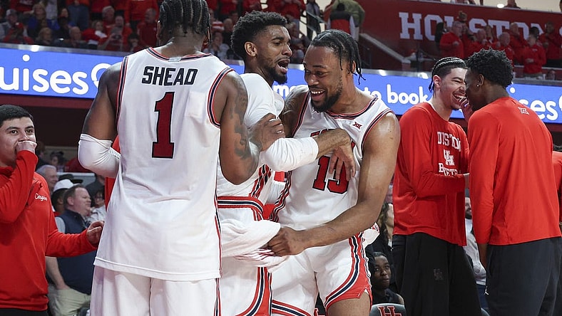Mar 9, 2024; Houston, Texas, USA; Houston Cougars forward J'Wan Roberts (13) celebrates with guard Mylik Wilson (8) and guard Jamal Shead (1) in the final minute of the game against the Kansas Jayhawks at Fertitta Center. Mandatory Credit: Troy Taormina-USA TODAY Sports