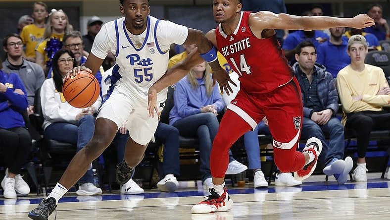 Mar 9, 2024; Pittsburgh, Pennsylvania, USA; Pittsburgh Panthers forward Zack Austin (55) drives the baseline against North Carolina State Wolfpack guard Casey Morsell (14) during the first half at the Petersen Events Center. Mandatory Credit: Charles LeClaire-USA TODAY Sports