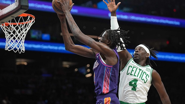 Mar 9, 2024; Phoenix, Arizona, USA; Phoenix Suns center Bol Bol (11) puts up a layup over Boston Celtics guard Jrue Holiday (4) during the first half at Footprint Center. Mandatory Credit: Joe Camporeale-USA TODAY Sports